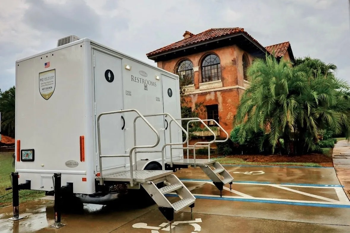 Interior of a Luxe Flush luxury restroom trailer with private toilet suites and wood flooring